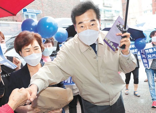 시장 방문 더불어민주당 이낙연 전 대표(오른쪽)가 8일 서울 금천구 비단길현대시장 상인회에서 열린 서울상인연합회 정책협약식에 참석해 시민들과 악수를 하고 있다. 사진공동취재단