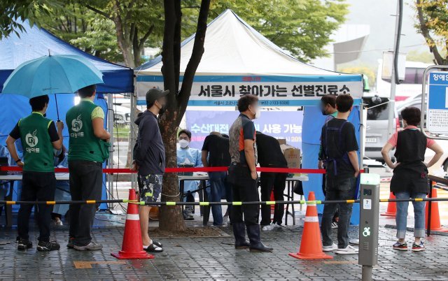 6일 오전 코로나19 확진자 집단감염이 발생한 서울 마포구 마포농수산물시장에 설치된 찾아가는 선별진료소에서 상인들이 검사를 받고 있다. 뉴시스