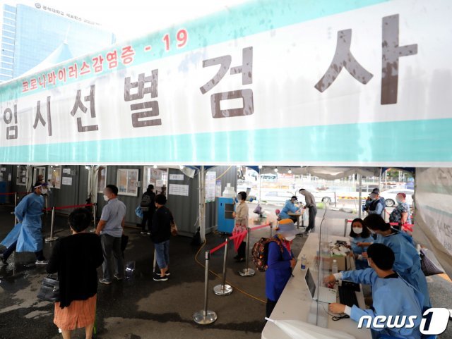 서울 중구 서울역 광장에 마련된 코로나19 임시선별검사소를 찾은 시민들이 검체 검사를 받기 위해 접수하고 있다./뉴스1 © News1