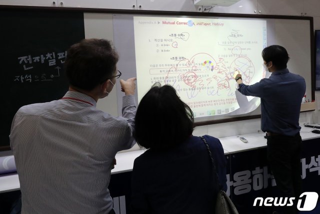 지난 5월17일 서울 강남구 코엑스에서 열린 ‘제18회 대한민국 교육박람회’에서 관람객들이 전자칠판을 체험하고 있다. (사진은 기사 내용과 무관함)/뉴스1 © News1