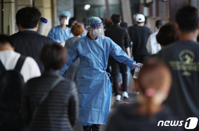 13일 오전 서울 송파구보건소에 마련된 신종 코로나바이러스 감염증(코로나19) 선별진료소를 찾은 시민들이 검사를 위해 의료진의 안내를 받아 이동하고 있다./뉴스1 © News1