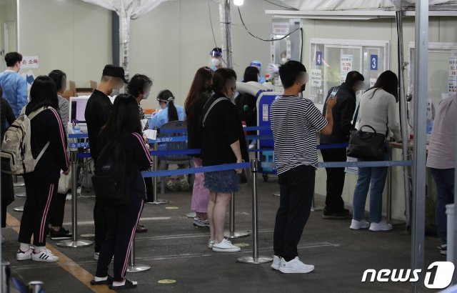 13일 오전 서울 송파구보건소에 마련된 신종 코로나바이러스 감염증(코로나19) 선별진료소를 찾은 시민들이 검사를 위해 접수하고 있다./뉴스1 © News1