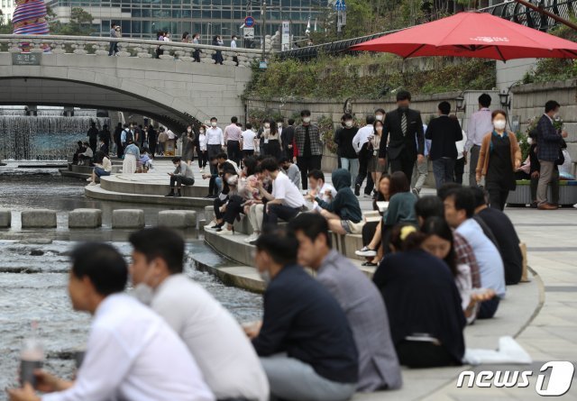 14일 오후 서울 중구 청계천에서 직장인들이 점심시간을 이용해 휴식을 취하고 있다. 신종 코로나바이러스 감염증(코로나19) 확산 방지를 위해 오는 18일부터 적용될 사회적 거리두기 조정안이 15일 발표된다. 2021.10.14/뉴스1 © News1