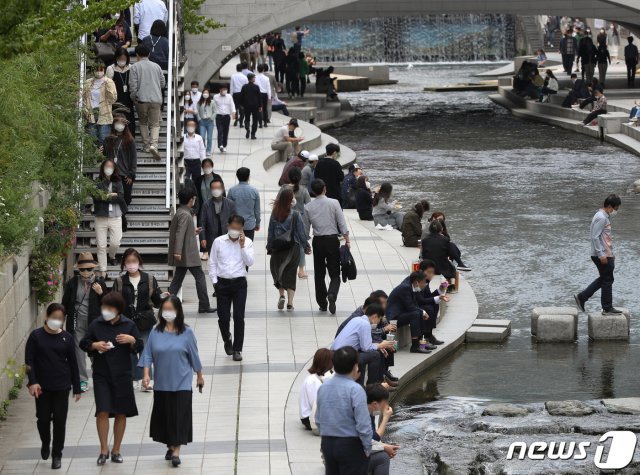 14일 오후 서울 중구 청계천에서 직장인들이 점심시간을 이용해 휴식을 취하고 있다.  © News1