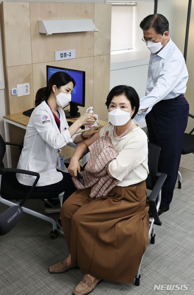 김정숙 여사가 15일 서울 국립중앙의료원 코로나19 중앙예방접종센터에서 코로나19 백신 추가 접종을 받자 문재인 대통령이 지켜보고 있다. 2021.10.15. 뉴시스