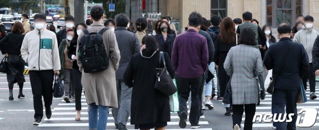 18일 오전 서울 종로구 광화문 네거리에서 두꺼운 겨울옷을 챙겨 입은 시민들이 출근길 발걸음을 재촉하고 있다. 2021.10.18/뉴스1 © News1