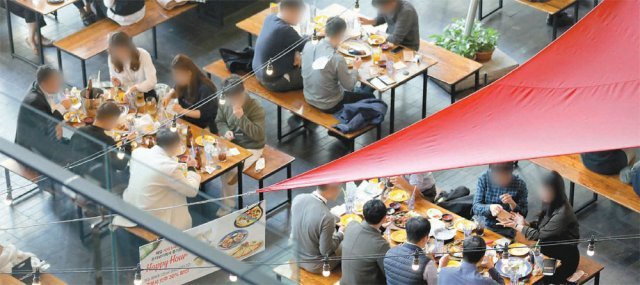 “최대 8명까지 같이 앉을 수 있어요” 수도권의 사적 모임 인원 제한이 접종 완료자 포함 최대 8명까지 늘어나는 거리 두기 조정안이 시행된 첫날인 18일, 서울 광화문 인근의 한 음식점 내 여러 테이블에서 6, 7명이 둘러앉아 함께 식사를 하고 있다. 뉴스1