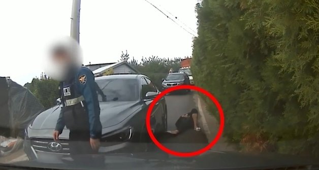 이 운전자는 경찰의 협조에도 응하지 않고 도로에 드러누웠다. (유튜브 ‘한문철TV’ 영상 갈무리) © 뉴스1