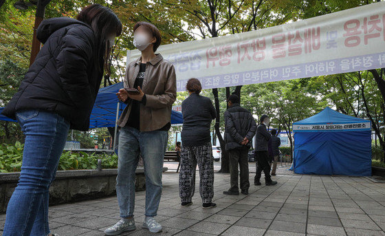19일 오전 서울 영등포구 중마루공원에 마련된 찾아가는 선별진료소에서 전통시장 상인 등 시민들이 검사를 받기 위해 줄을 서있다.  2021.10.19/뉴스1 © News1