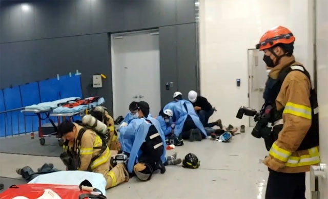 23일 화재 진압용 가스 누출 사고가 발생한 서울 금천구 가산동의 건물 공사 현장에서 구급대원들이 구조된 근무자들에게 심폐소생술(CPR)을 실시하고 있다. 이날 사고로 지하 3층에서 일하던 2명이 숨지고 2명이 중상을 입는 등 21명의 사상자가 발생했다. 소방당국 제공