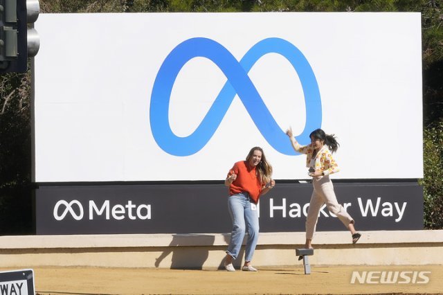 28일(현지시간) 미 캘리포니아주 멘로파크 페이스북 본사 직원들이 회사의 새 로고 앞에서 기념사진을 
찍고 있다. 멘로파크=AP/뉴시스