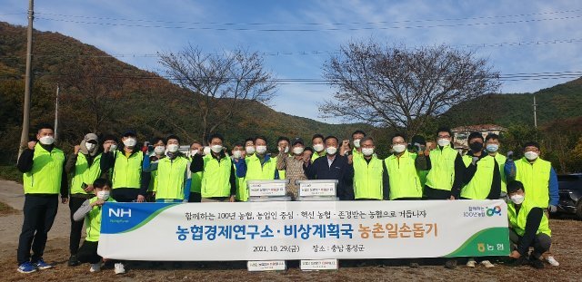 농협중앙회 농협경제연구소는 29일 충남 홍성에서 일손돕기를 실시했다. 앞줄 왼쪽 여섯번째부터 조소행 농협경제연구소 소장, 박영순 홍성군 
동막마을 이장, 이의수 홍성 갈산농협 조합장, 길정섭 농협중앙회 충남지역본부장을 비롯한 참석자들이 기념촬영을 하고 있다. 농협 제공