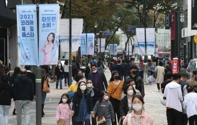 위드코로나로 활기찾는 거리
 위드코로나(단계적 일상회복) 1단계를 하루 앞둔 31일 오후 서울 명동거리에 휴일을 맞은 가족 단위 시민들이 1일부터 15일까지 코리아세일 페스타를 알리는 현수막이 걸려 있는 거리를 걷고 있다.