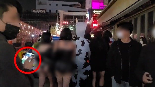 이 남성은 휴대전화 카메라를 켠 뒤 여성들 뒤로 다가갔다. (유튜브 갈무리) © 뉴스1