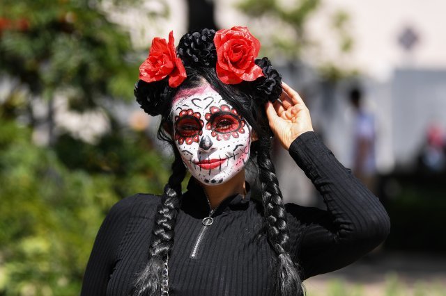1일 멕시코 수도 멕시코시티 시내에서 죽은 자의 날 퍼레이드에 참가한 유령 화장과 의상을 입은 여성이 사진을 위해 포즈를 취하고 있다. 신화 뉴시스