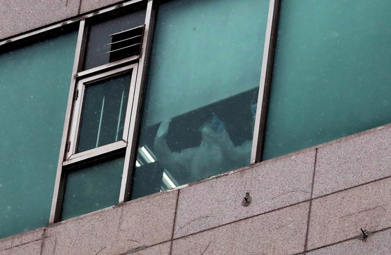경기 부천시 효플러스요양병원에서 의료관계자들이 창문을 통해 밖을 살펴보고 있다. /뉴스1