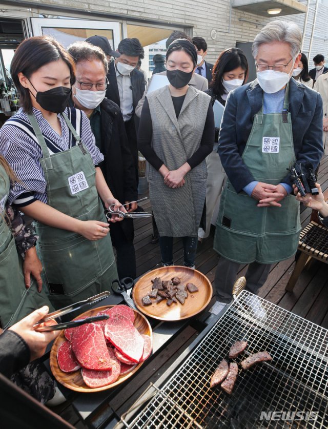 청년들과 같이 고기 구우며 대화하는 이재명 후보. 뉴시스