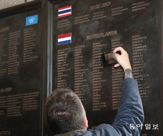 네델란드참전용사 가족이 전사자명비에 새겨진 이름을 휴대폰에 담고있다.