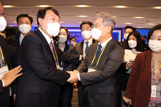 이재명 더불어민주당 대선 후보와 윤석열 국민의힘 대선 후보(왼쪽)가 10일 서울 광진구 비스타워커힐에서 열린 ‘글로벌인재포럼2021’ 행사에서 만나 악수하고 있다. 맨 오른쪽은 심상정 정의당 대선후보.  © News1 국회사진취재단