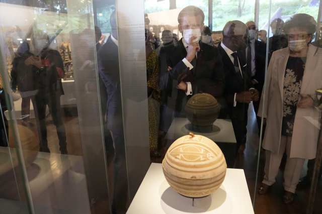 에마뉘엘 마크롱(가운데) 프랑스 대통령이 27일(현지시간) 프랑스 파리의 케 브랑리 박물관에서 전시 중인 아프리카 베냉 미술품을 관람하고 있다. 프랑스 정부는 식민지 시대 아프리카 베냉에서 약탈했던 주요 미술품 26점을 다음 달 반환한다. 2021.10.28. AP/뉴시스