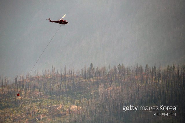 올해 7월 2일 캐나다 브리티시컬럼비아주 리턴 지역 근처의 프레이저 강을 따라 헬리콥터가 물을 떨어뜨릴 준비를 하고 있다. 올해 여름, 장기간의 폭염으로 인해 캐나다 서부 지방에서 수십 건의 산불이 발생했다. ⓒ(GettyImages)/코리아