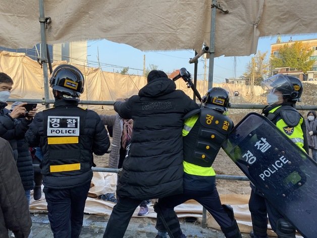 15일 오전 사랑제일교회 신도 1명이 경찰을 피해 교회 인근으로 넘어가려고 시도하고 있다. © 뉴스1