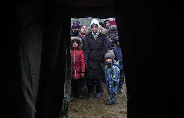 14일(현지시간) 벨라루스와 폴란드 국경 지대 그로드노에서 난민들이 인도주의적 원조를 받기 위해 줄 서 있다. 뉴시스