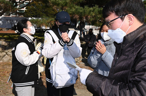 2022학년도 대학수학능력시험(수능)을 하루 앞둔 17일 오전 서울 서대문구 이화여자외국어고등학교에서 교사가 예비소집에 참여한 수험생에게 수험표를 전달하고 있다. /뉴스1 © News1 사진공동취재단