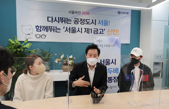 19일 서울 중구 신한은행 시청금융센터에서 열린 ‘희망두배 청년통장 신규참여자 통장 개설 행사’에서 오세훈 서울시장이 청년통장에 신규 가입한 시민들과 대화를 나누고 있다. 2021.11.19/뉴스1 © News1