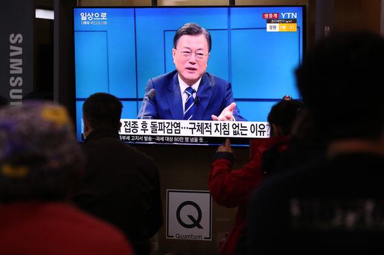 21일 오후 서울역 대합실에서 시민들이 문재인 대통령의 2021 국민과의 대화 ‘일상으로’를 시청하고 있다. 뉴스1