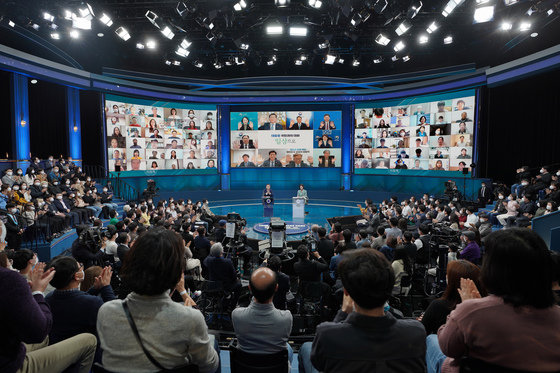 문재인 대통령이 21일 저녁 서울 여의도 KBS에서 열린 2021 국민과의 대화 ‘일상으로’에서 비대면으로 참석한 국무위원들의 인사에 박수치고 있다. 뉴스1