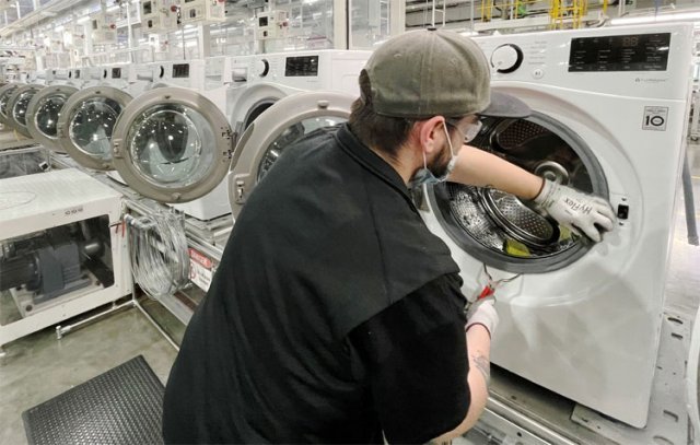 “바쁘다” LG전자 美공장 26일(현지 시간) 미국 테네시주 클라크스빌에 있는 LG전자 세탁기 생산라인에서 현장 관계자가 드럼 세탁기를 점검하고 있다. LG전자 제공