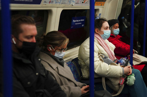 신종 코로나바이러스 감염증(코로나19)의 새 변이인 오미크론이 빠르게 확산되는 가운데 30일(현지 시간) 영국 런던 지하철 이용객들이 마스크를 모두 착용한 채 앉아 있다. 오미크론 변이 감염 사례가 11건으로 늘어난 영국은 다시 대중교통 이용 시 마스크 착용을 의무화했다. 런던=AP 뉴시스