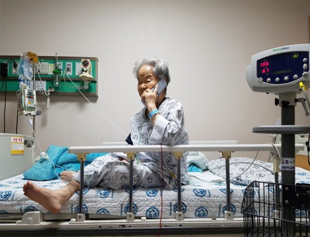 2018년 2월 100세인 김모 할머니가 오른쪽 심장동맥의 막힌 곳을 뚫고 스텐트를 삽입하는 시술 후 병상에서 자식에게 전화하고 있다. 전남대 의대 조정관 교수 제공
