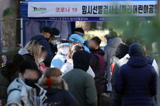 5일 오후 인천 연수구 고려인 밀집구역 함박마을에 마련된 임시선별진료소에서 외국인과 시민들이 검사를 기다리고 있다. 방역당국은 신종 코로나바이러스 감염증(코로나19) 변이 바이러스인 오미크론 첫 확진자인 인천 지역 목사 부부로부터 감염된 남성의 부인이 외국인을 대상으로 한 교회 행사에 참여한 것으로 확인했다. 인천시는 지역 고려인 대다수가 모여 사는 함박마을 특수성을 고려, 지난 4일부터 이날까지 선별진료소를 운영한다고 밝혔다. 2021.12.5/뉴스1 © News1