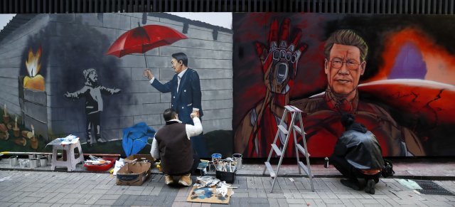 5일 서울 종로구의 한 중고서점 외벽에 왼쪽부터 순서대로 국민의힘, 더불어민주당 대선 후보로 보이는 인물들의 새 벽화가 그려지고 있다. 뉴스1