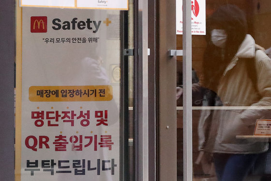 사적모임 인원 제한 등 강화된 방역조치가 시작된 6일 서울의 한 패스트푸드점 출입문에 입장 전 QR체크인을 권하는 안내문이 게시돼 있다.  2021.12.6/뉴스1 © News1