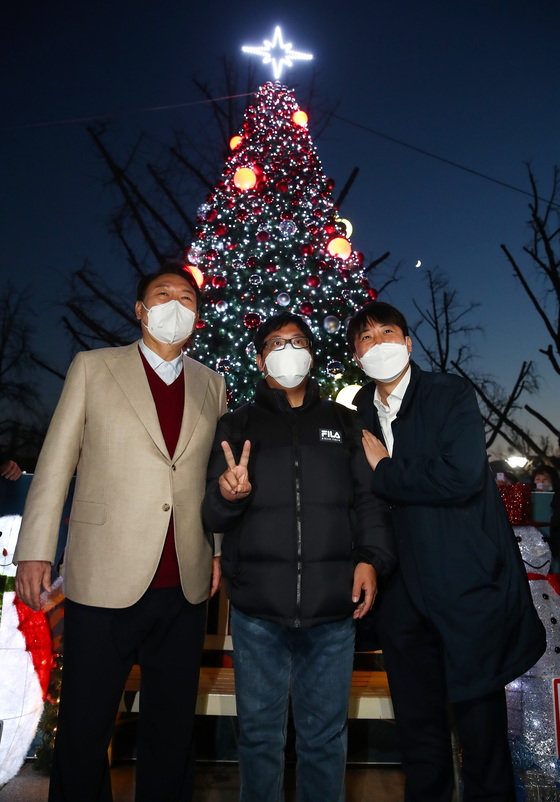 윤석열 국민의힘 대선 후보(왼쪽)와 이준석 대표가 8일 서울 종로구 대학로에서 거리인사 중 마로니에공원 내 트리 앞에서 시민들과 기념촬영을 하고 있다. 2021.12.8/뉴스1 © News1