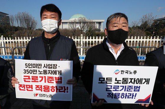 양경수 민주노총 위원장(왼쪽)과 김동명 한국노총 위원장이 8일 서울 여의도 국회 앞에서 열린 모든 근로자 근로기존법 적용, 노동기본권 보장, 고용승계 보장을 촉구하는 양대노총 위원장 공동기자회견에서 피켓을 들고 있다. 2021.12.8/뉴스1 © News1