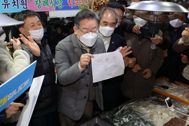이재명 더불어민주당 대선 후보가 5일 오전 전북 정읍 샘고을시장을 방문해 떡을 구입하고 있다. 뉴스1