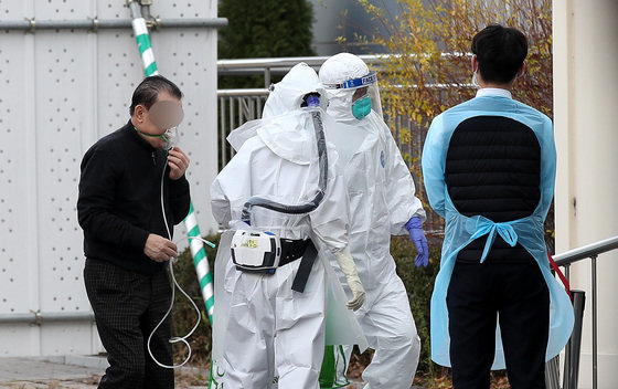 지난 6일 오후 서울 중랑구 서울특별시 서울의료원에서 의료진들이 신종 코로나바이러스 감염증(코로나19) 확진 환자를 안내하고 있다. 2021.12.6/뉴스1 © News1