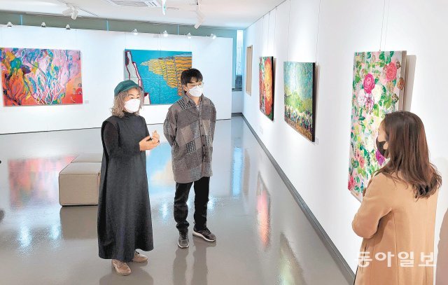 8일 서울 강동구에 있는 서울시민대학 동남권 캠퍼스 내 갤러리. 대학시절 같은 실기실을 썼던 동기 7명과 함께 12월 이곳에서 
‘Project 1+10’ 전시를 선보이고 있는 이영신 작가(왼쪽)가 전시작품 앞에서 설명을 하고 있다. 김동주 기자 
zoo@donga.com