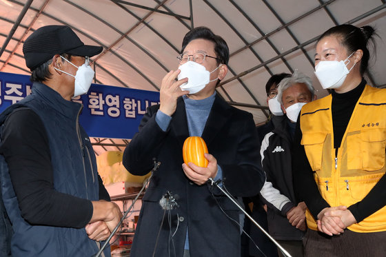 매타버스(매주 타는 민생버스) 다섯번째 행선지로 고향인 대구·경북(TK)을 찾은 이재명 더불어민주당 대선 후보가 13일 오전 경북 성주군 참외 농가를 방문해 성주 참외 모종심기를 체험한 후 농민들과 참외를 들고 대화하고 있다. 2021.12.13/뉴스1 © News1