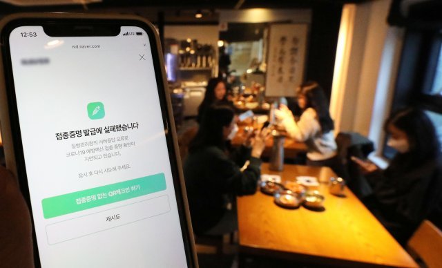 방역패스(접종증명·음성확인제)의 계도기간이 끝나고 의무화가 시작된 13일 서울시내의 한 식당에서 손님이 접종증명 발급 오류 화면을 보이고 있다. 뉴스1