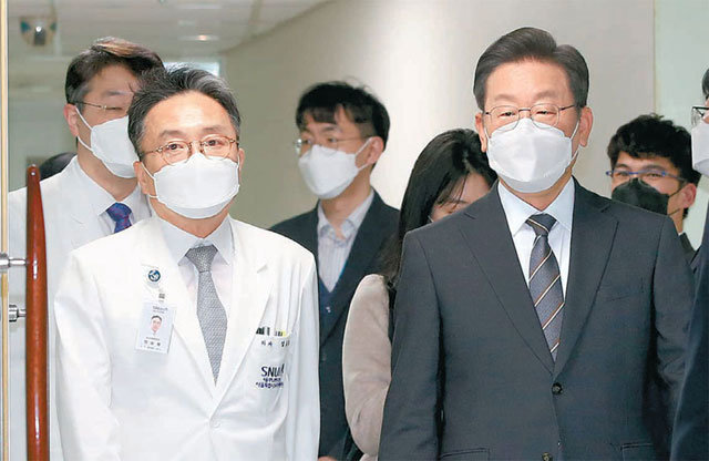 더불어민주당 이재명 대선 후보(오른쪽)가 15일 오후 서울 동작구 서울시 보라매병원을 방문해 정승용 병원장(왼쪽)의 안내로 신종 코로나바이러스 감염증(코로나19) 방역 대응 상황을 살펴보고 있다. 뉴시스