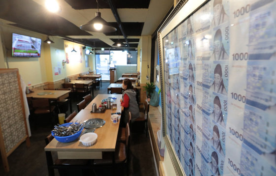 정부의 사회적 거리두기 강화 발표를 앞둔 15일 서울의 한 식당에 번창을 위해 지인이 선물한 1천원짜리 액자가 벽면에 걸려 있다. 테이블은 텅 비어있다.  2021.12.15/뉴스1 © News1