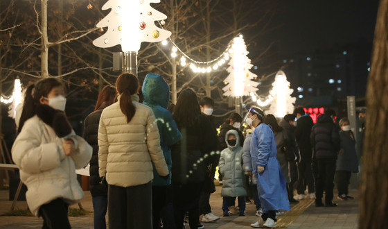 신종 코로나바이러스 감염증(코로나19) 확산으로 인해 정부가 단계적 일상회복(위드코로나)를 잠시 멈추고 강화된 방역조치를 발표한 16일 오후 서울 서대문구 신촌역 광장에 마련된 선별진료소를 찾은 시민들이 크리스마스 트리 조명 아래서 코로나19 검사를 기다리고 있다. 2021.12.16/뉴스1 © News1