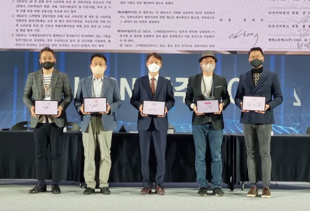 서명한 태블릿을 든 (왼쪽부터) 인사이터스 황현철대표, 인터비즈 정언용 팀장, 인공지능산업융합사업단 임차식 단장, 아이티동아 강덕원 대표, 에이빙뉴스 최지훈 대표 (출처=IT동아)
