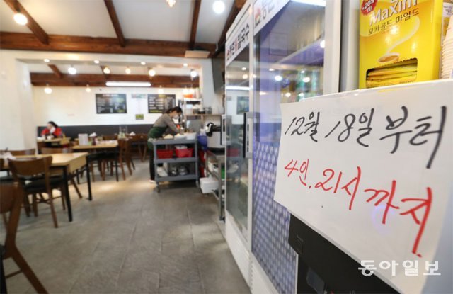 16일 서울 은평구의 한 식당에 ‘4인, 21시까지’라는 안내문구가 적혀 있다. 정부가 단계적 일상 회복을 중단하고 사회적 거리 
두기를 시행하기로 함에 따라 18일부터 전국적으로 사적 모임은 4명까지, 식당·카페 영업시간은 오후 9시까지로 제한된다. 김재명 
기자 base@donga.com