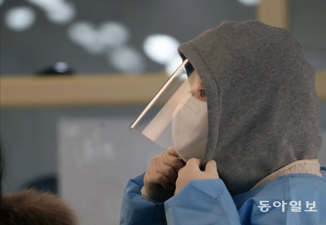 17일 서울역에 마련된 코로나19 임시선별검사소에서 한 의료진이 영하의 날씨에 옷깃을 여미고 있다.